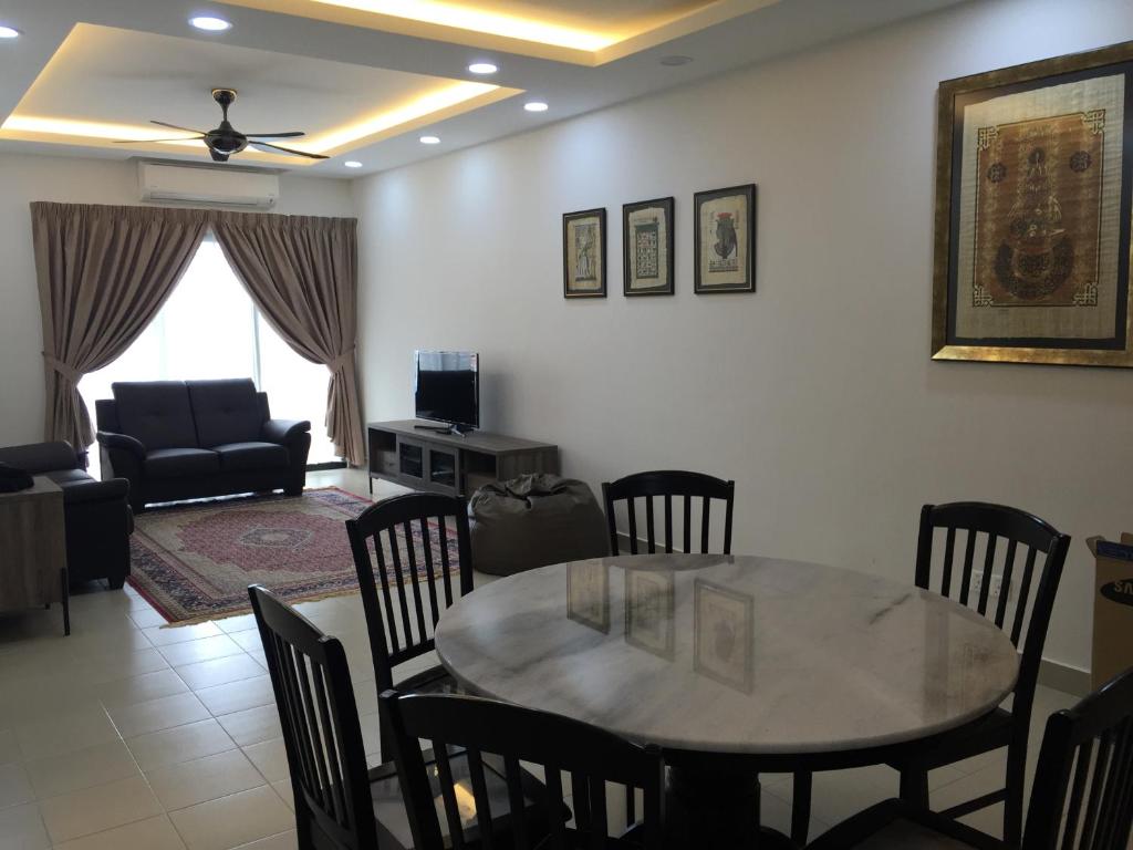 sala de estar con mesa, sillas y sofá en Rusnoor Homestay Alami Residensi 2-17-2, en Shah Alam