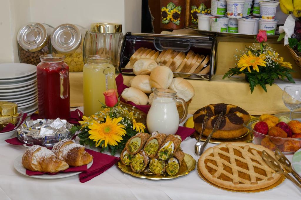 a table topped with bread and pastries and milk at Hotel Sylesia in Letojanni