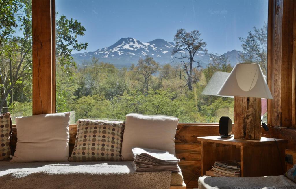 a living room with a couch and a view of a mountain at Onai Hostel in Las Trancas