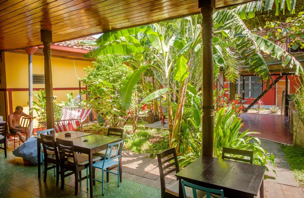 a patio area with tables, chairs and umbrellas at Hostel De Boca en Boca in Granada