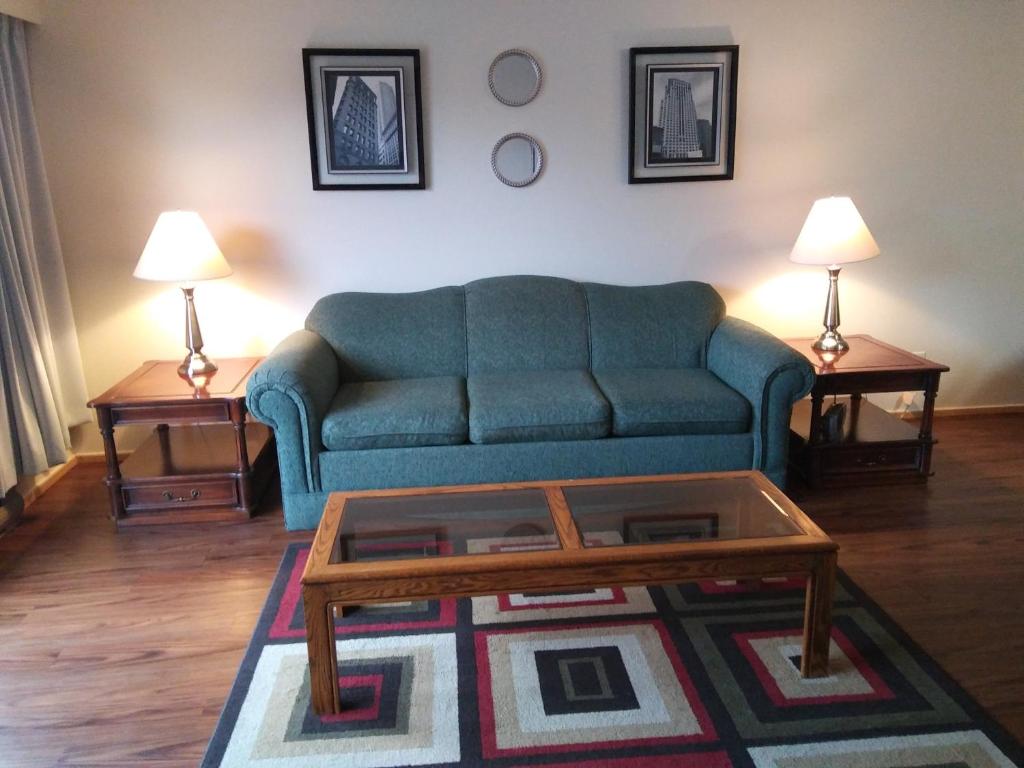 a living room with a blue couch and two tables at Rosedale Manor in Duncan