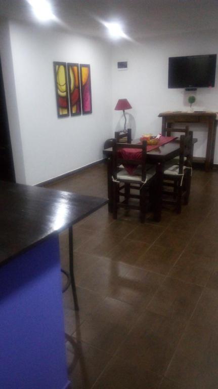 ein Wohnzimmer mit einem Tisch und Stühlen sowie einem TV in der Unterkunft Alquileres La Deseada in San Clemente del Tuyú