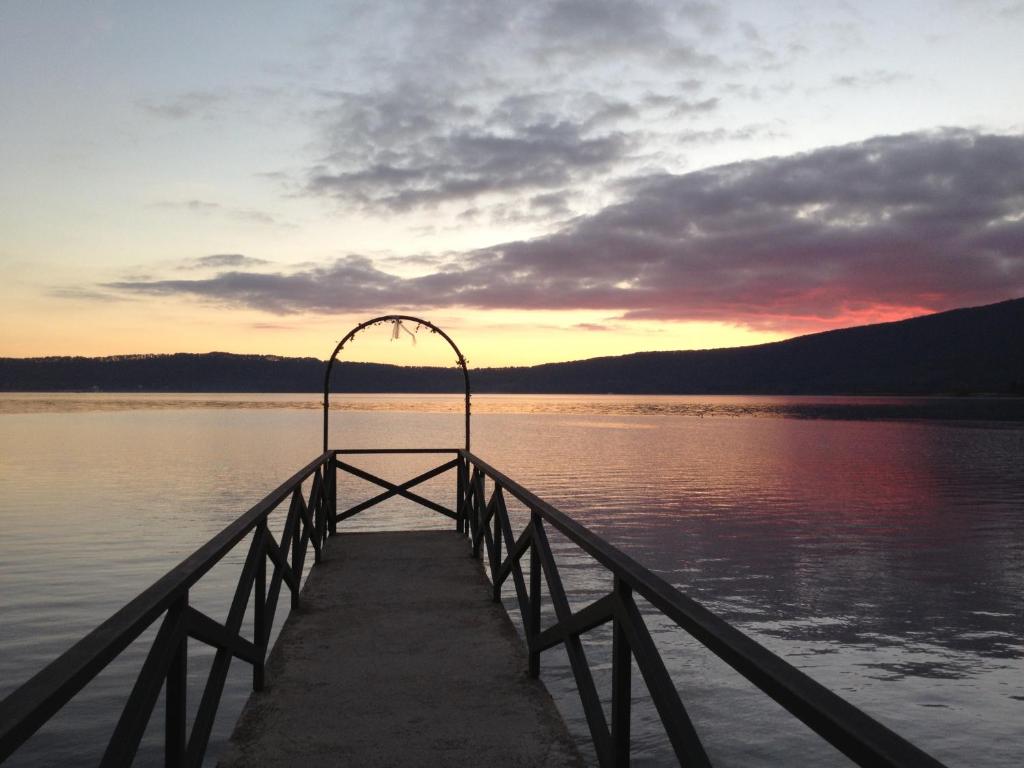 a dock on a body of water with a sunset at Hotel La Bella Venere in Caprarola