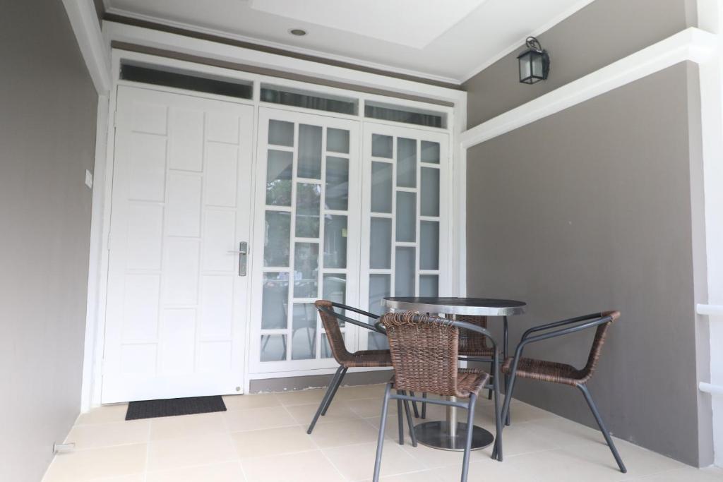 comedor con 2 sillas y mesa en Diyar Villas Puncak M3/8, en Puncak