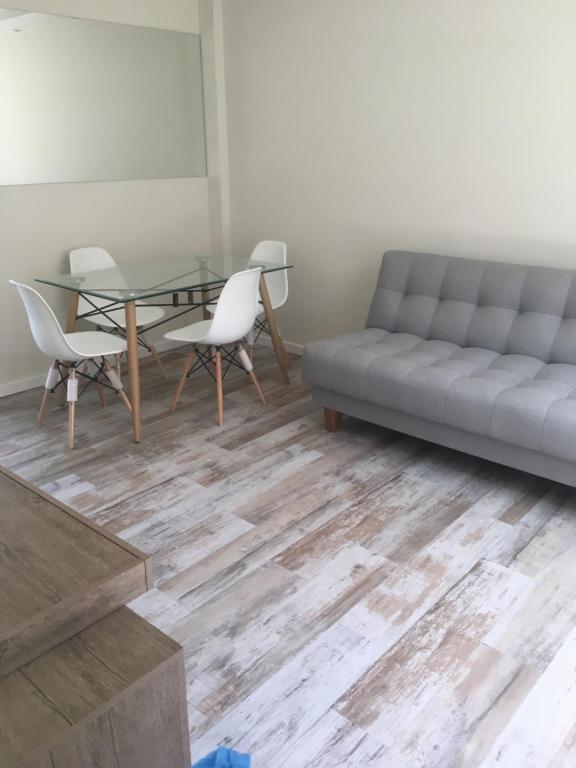 a living room with a couch and a table and chairs at Plaza Cagancha in Montevideo