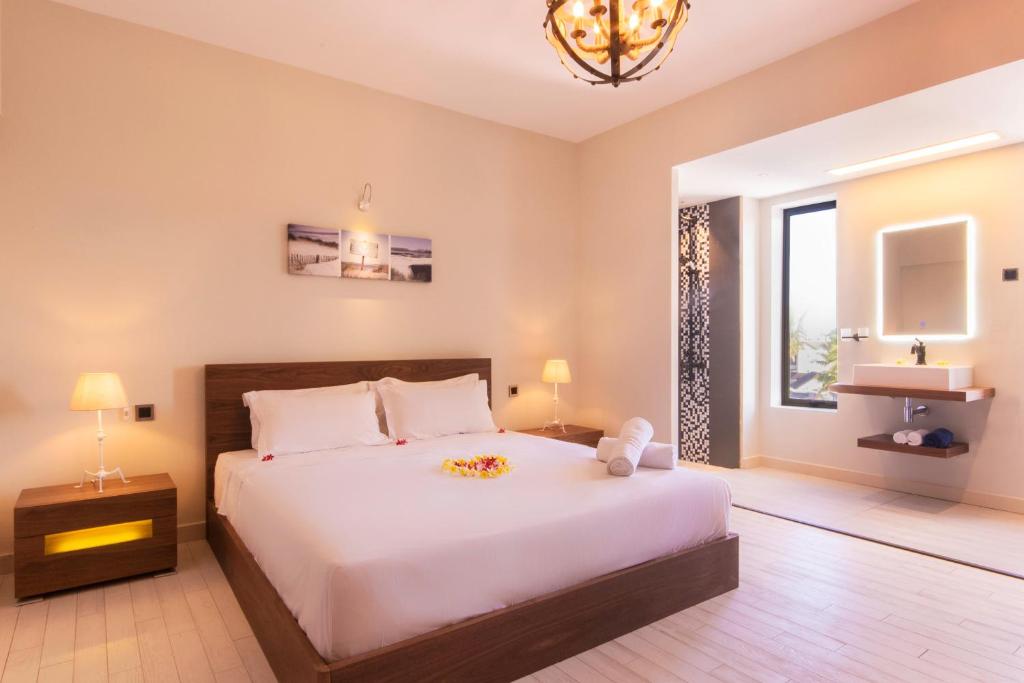 a bedroom with a large white bed and a window at Azure Beach Boutique Hotel in Grand-Baie