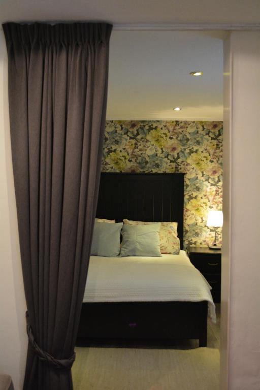a bedroom with a large bed with a curtain at Suite 17 in Eindhoven