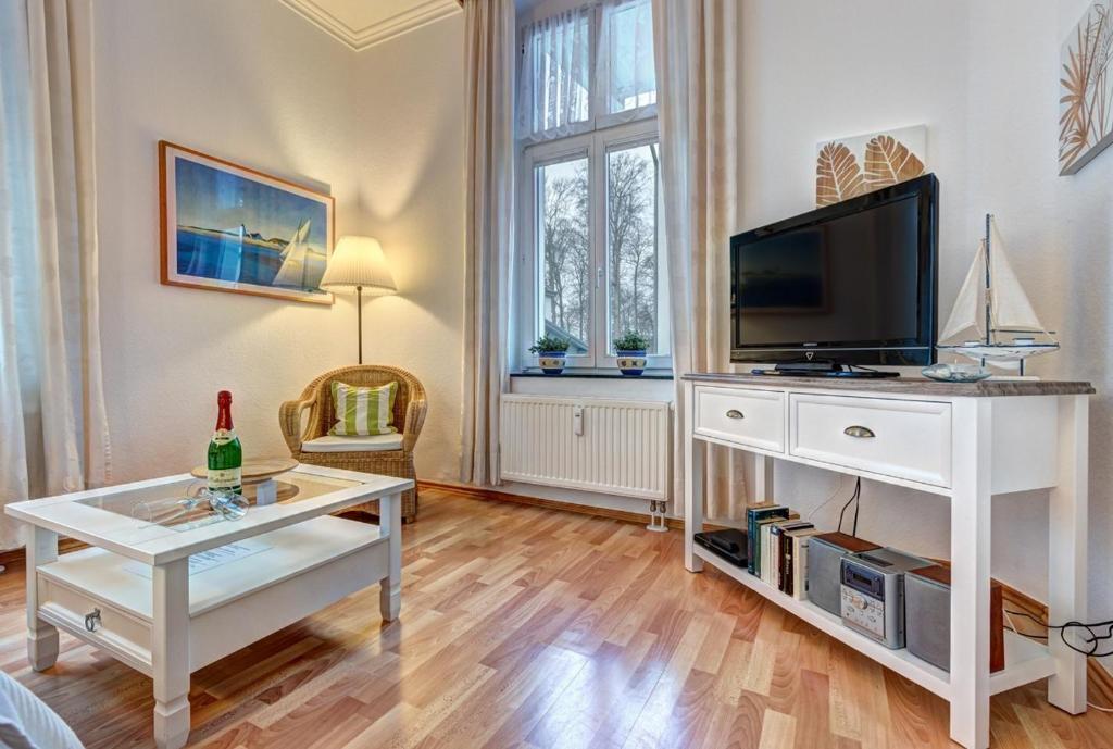 ein Wohnzimmer mit einem TV und einem Tisch in der Unterkunft Villa Frieda Wohnung 2 in Bansin