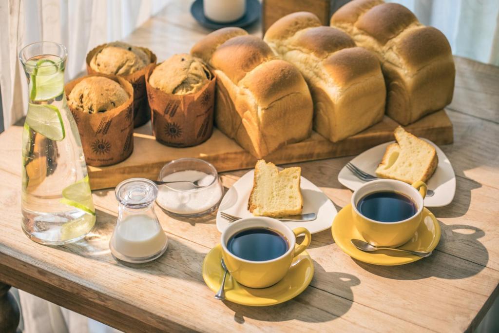 a table with two cups of coffee and bread at Sunday Home in Dayin