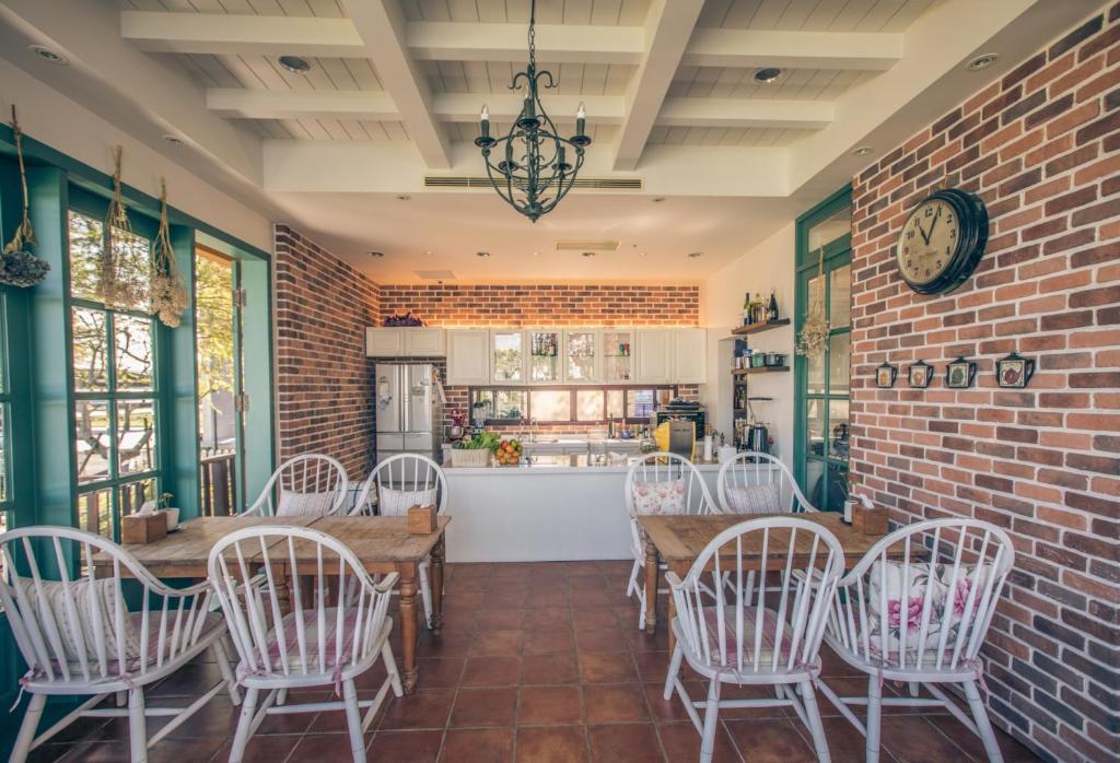 a dining room with a brick wall and a table and chairs at Sunday Home in Dayin
