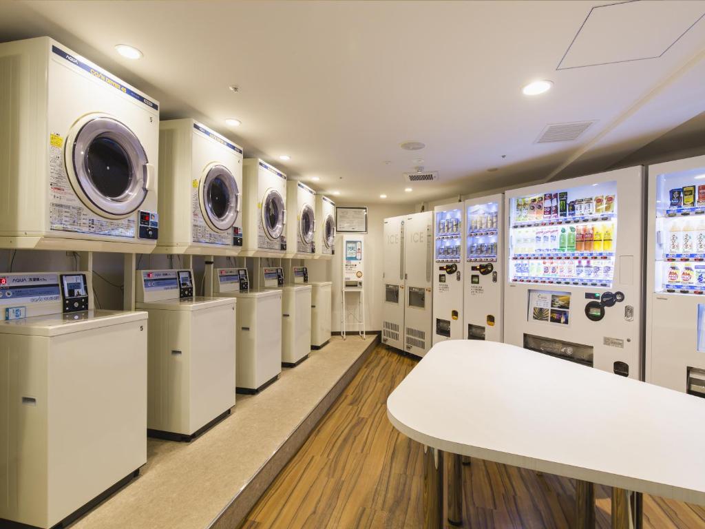 a laundry room with white washers and dryers at Sheraton Okinawa Sunmarina Resort in Onna