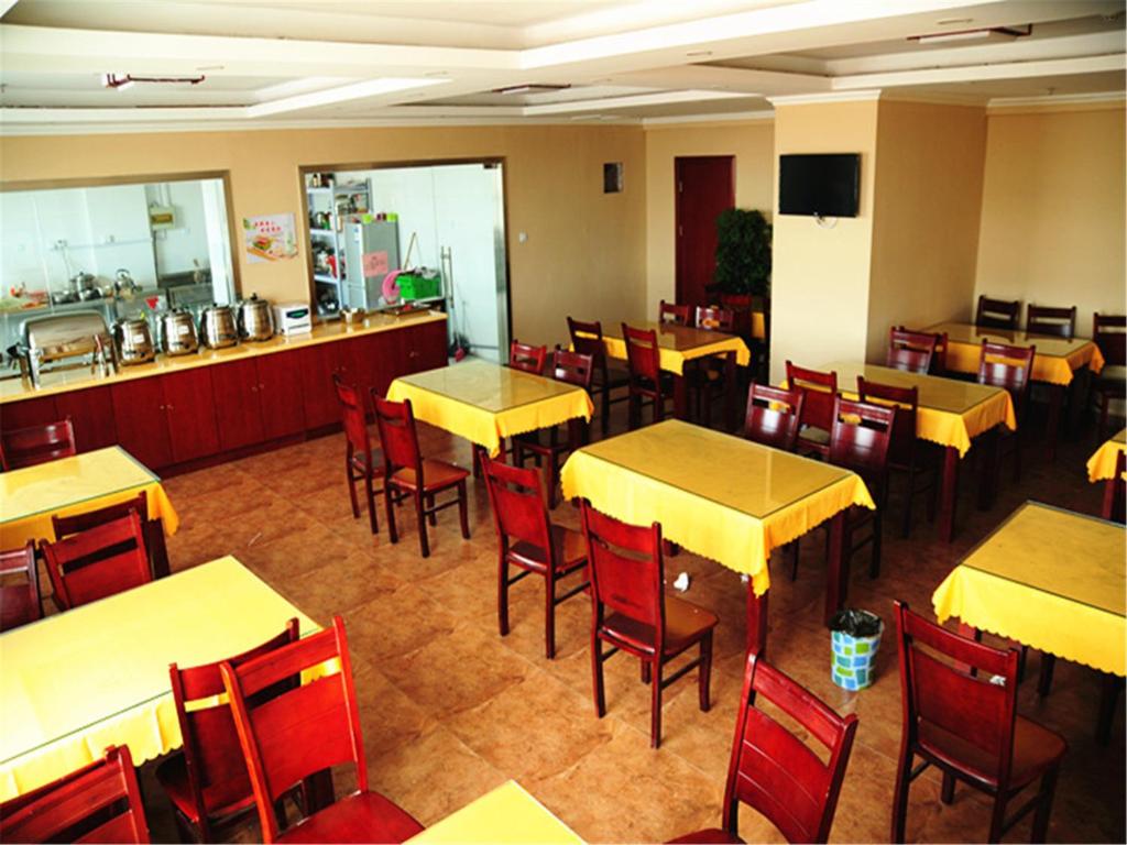 a restaurant with yellow tables and red chairs at GreenTree Inn Changzhou Zhongwu Road university of Technology Express Hotel in Changzhou