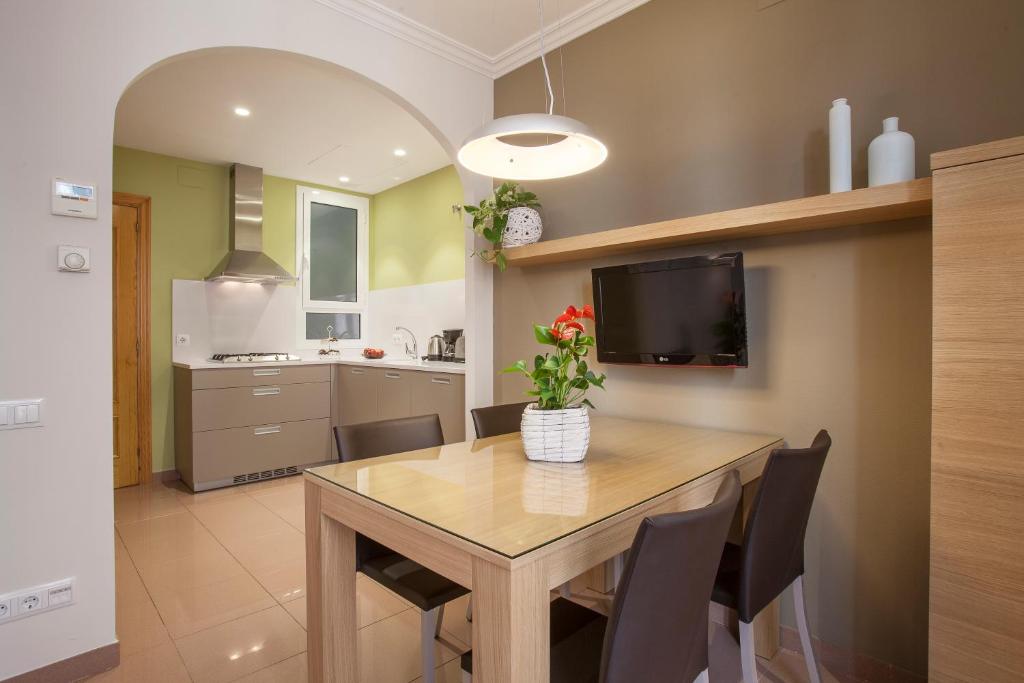 巴塞隆納的住宿－Bcngotic，厨房配有餐桌、椅子和电视