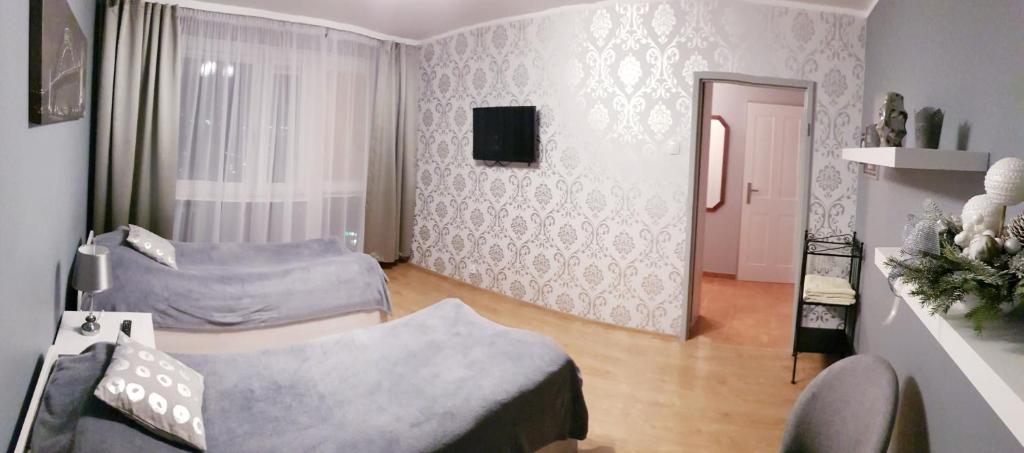 Il comprend un salon doté d'un canapé et d'une télévision. dans l'établissement Apartament Silver, à Kielce