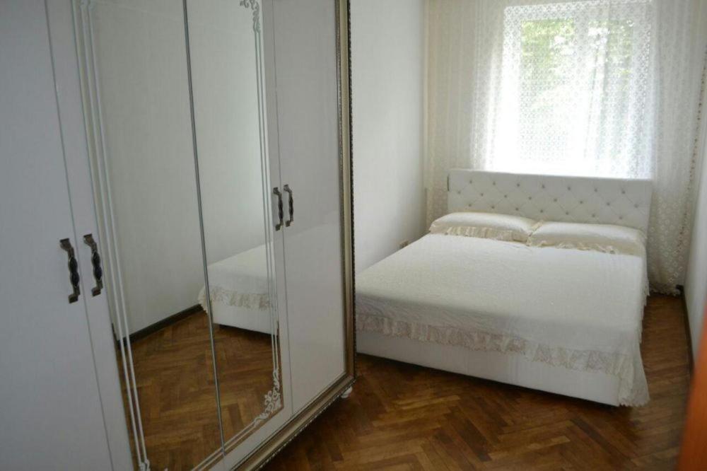 リウネにあるЧудова квартира в центрі містаのベッドの横に鏡が付くベッドルーム