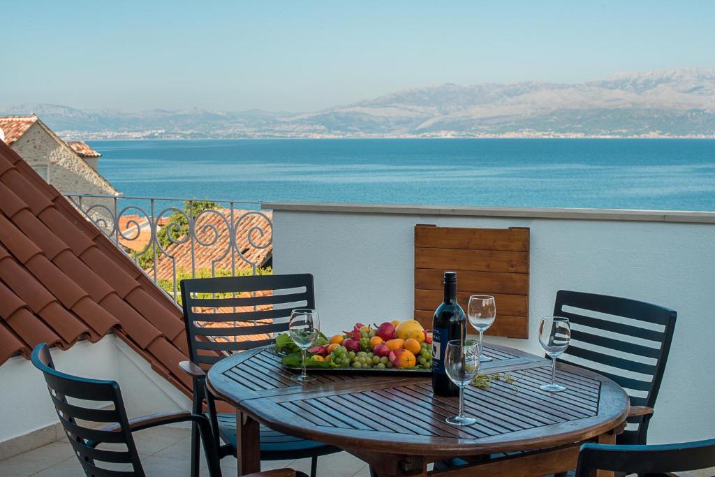 a table with a bowl of fruit and wine glasses at Villa Opera Garden in Sutivan