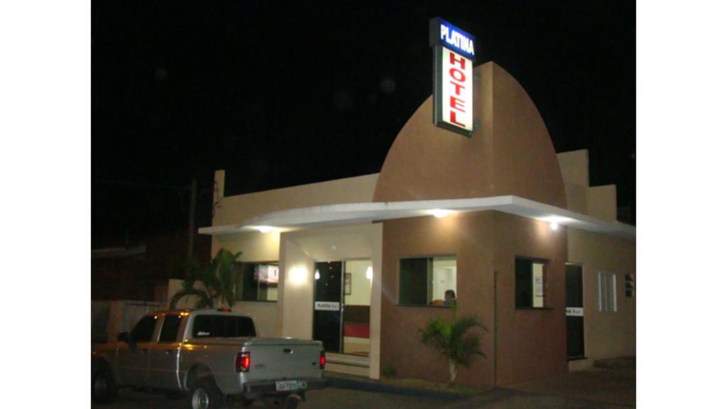 a truck parked outside of a gas station at night at Hotel Platina in Santo Antônio da Platina