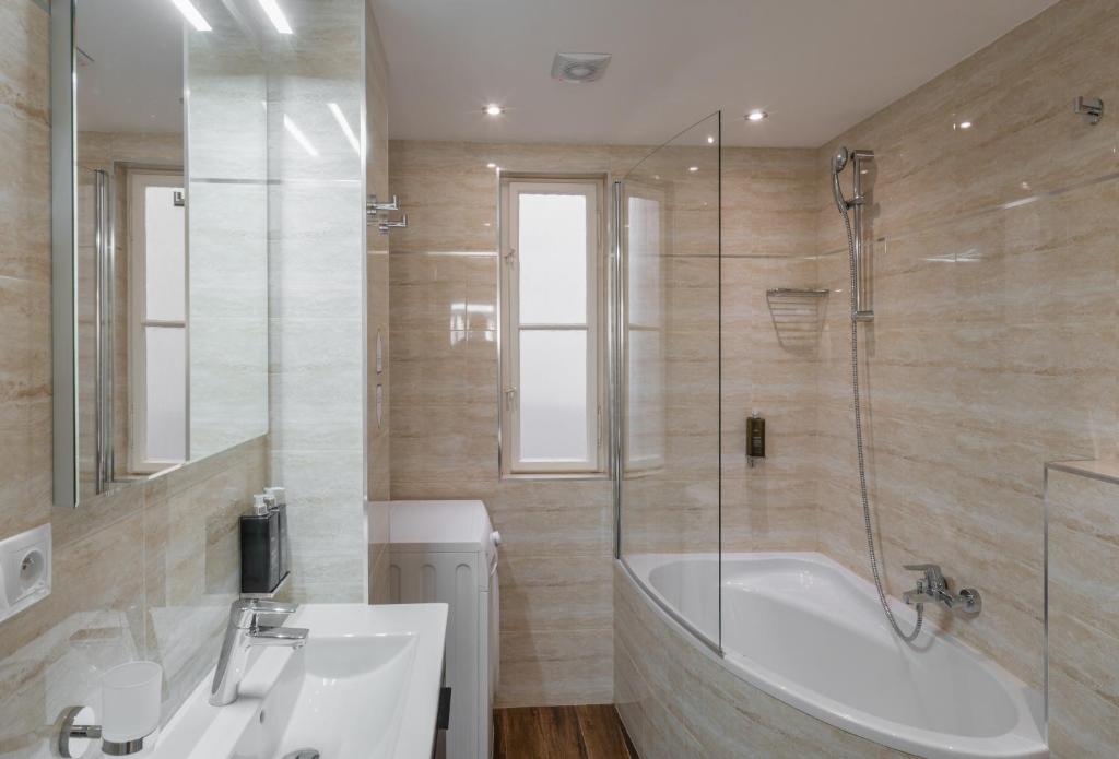 W łazience znajduje się wanna, umywalka i prysznic. w obiekcie Mordecai 12 Apartments by Adrez w Pradze
