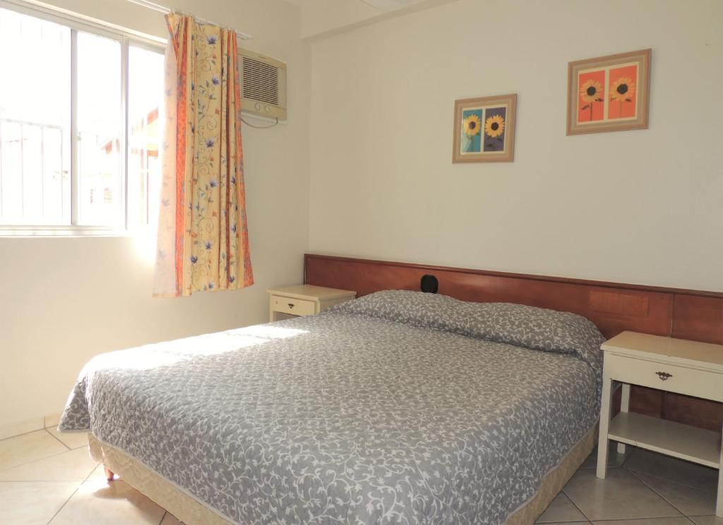 Schlafzimmer mit einem Bett und einem Fenster in der Unterkunft Residencial Kelly Cristina in Bombinhas