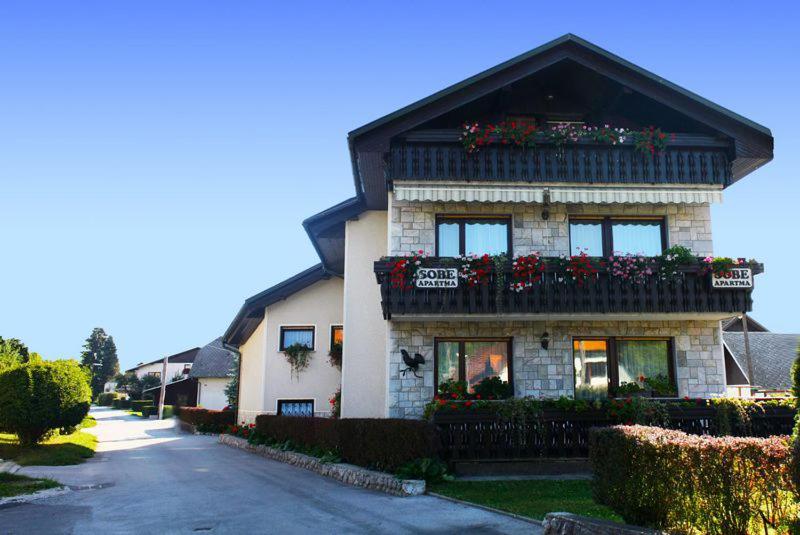 a building with flower boxes on the side of it at Sobe apartma Milena in Bled