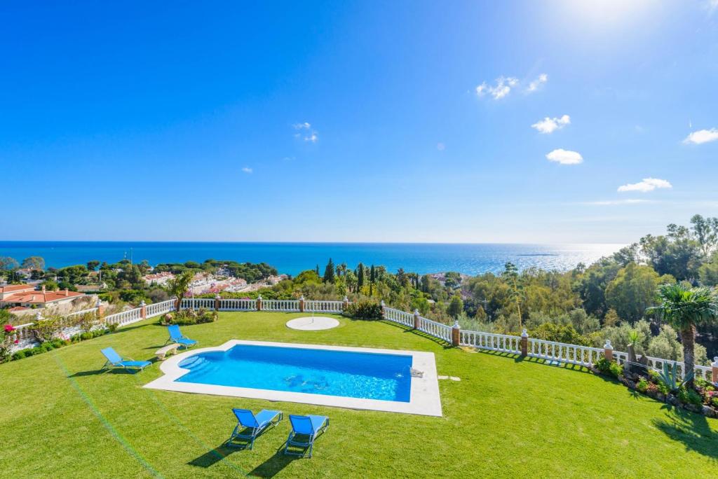 ベナルマデナにあるCubo's Villa Las Colinasのスイミングプールと海を望む庭園の空中ビュー