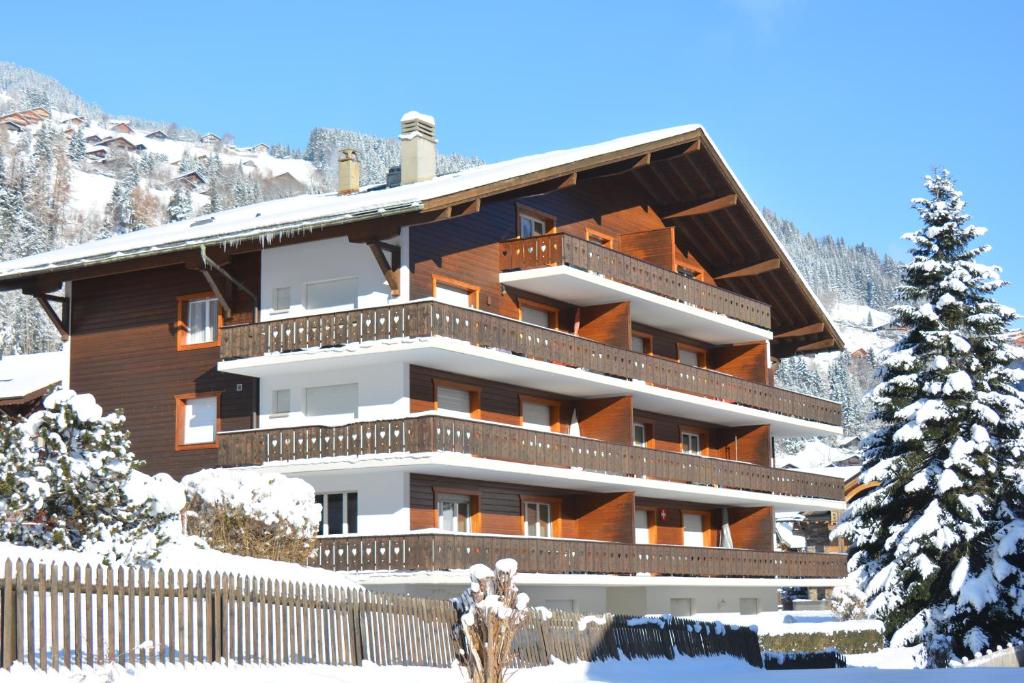 ein Gebäude im Schnee mit einem Zaun in der Unterkunft Apartment Champéry Grand Pré A in Champéry