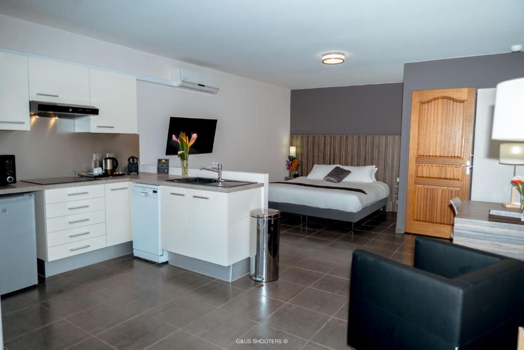 eine Küche mit einem Waschbecken und ein Zimmer mit einem Bett in der Unterkunft Eclipse Belle Etoile Appart'hôtel in Cayenne