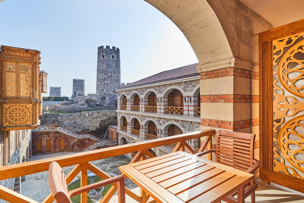 a balcony with a table and a view of a city at Hotel Gino Wellness Rabath in Akhaltsikhe