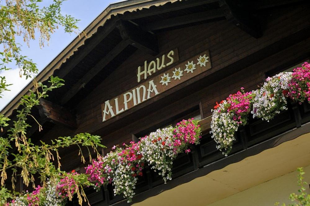 a bunch of flowers in boxes on a building at Haus Alpina in Häselgehr