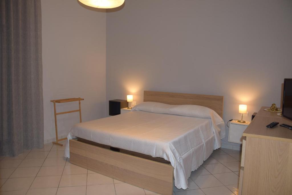 a bedroom with a white bed and a television at Diana e Atteone in Caserta