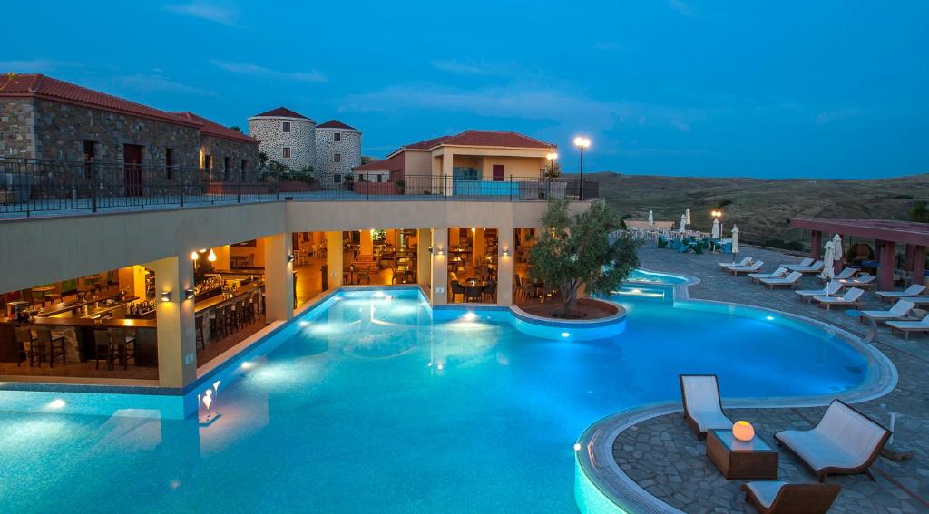 a hotel with a large swimming pool at night at Varos Village Boutique Hotel - Holistic Experience in Város