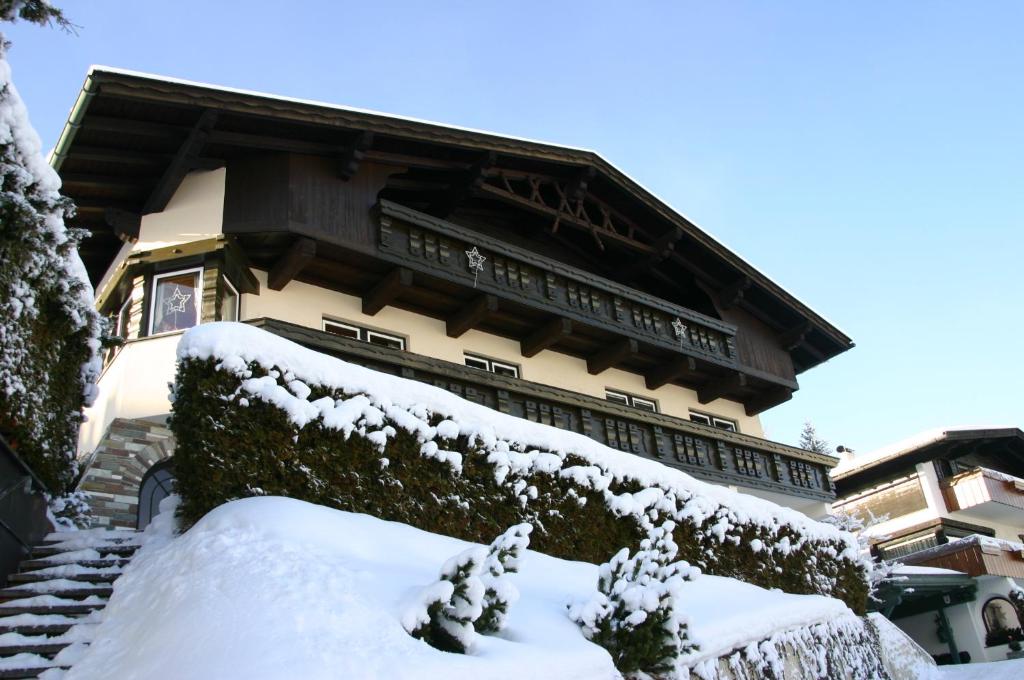 ein schneebedecktes Gebäude mit einer Treppe vor dem Gebäude in der Unterkunft Haus Salzburg in Seefeld in Tirol
