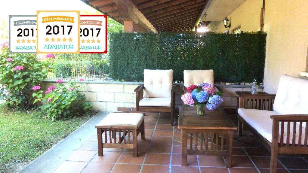 un patio con 2 sillas y una mesa con flores. en Casa Respal EVI00158, en Respaldiza