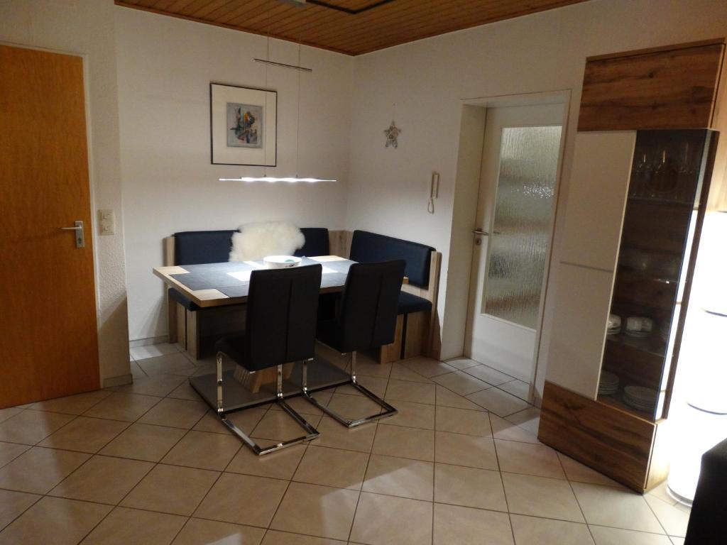 ein Esszimmer mit einem Tisch und schwarzen Stühlen in der Unterkunft Ferienwohnung "Am Rothaarsteig" in Winterberg
