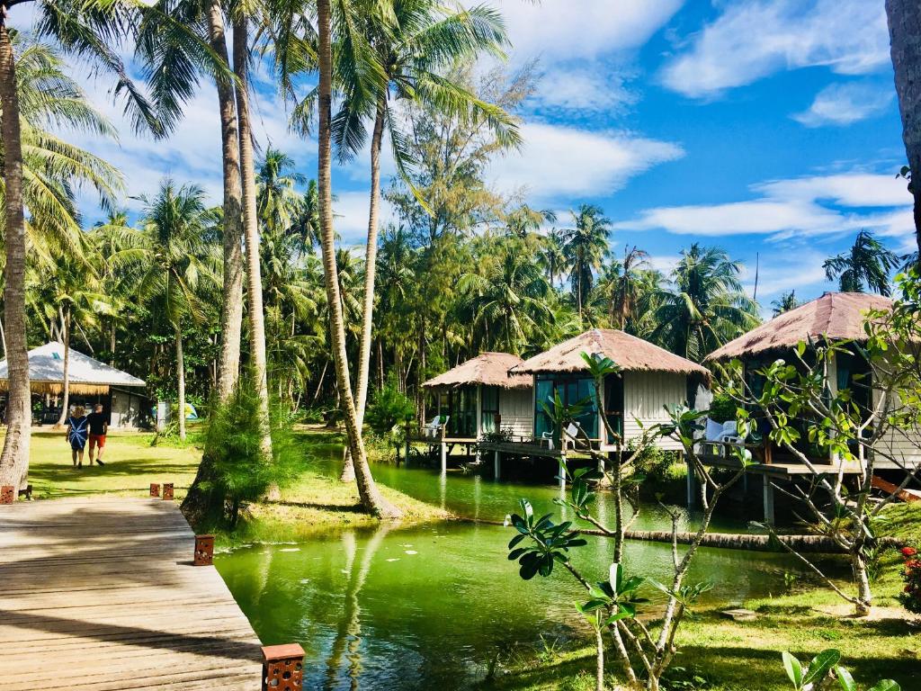 a resort with palm trees and a body of water at Prompakdee Kohmak Resort in Ko Mak