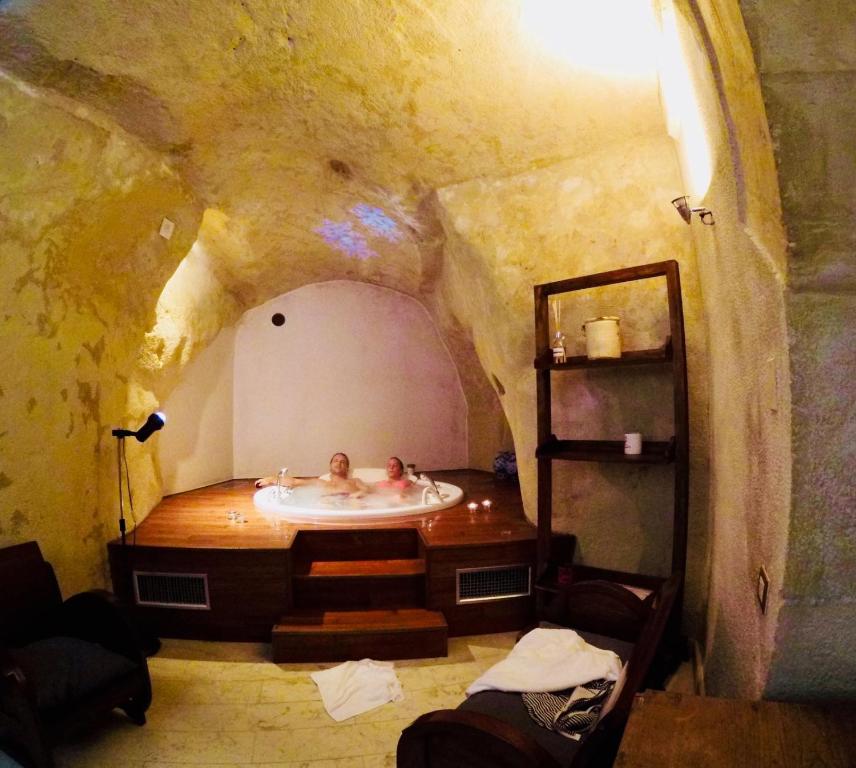 een man in een bad in een kamer met een boog bij Locus Amoenus in Matera