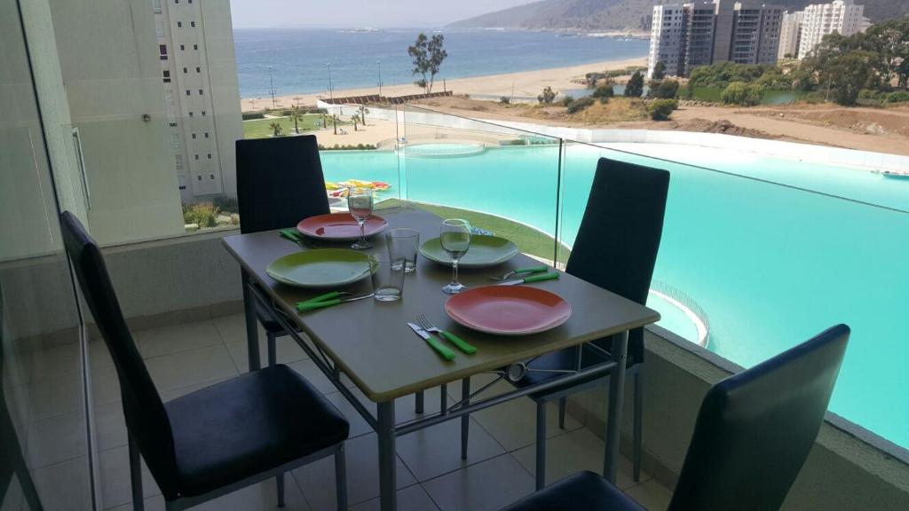 - une table à manger avec des chaises et une vue sur l'océan dans l'établissement Papudo Laguna, à Papudo