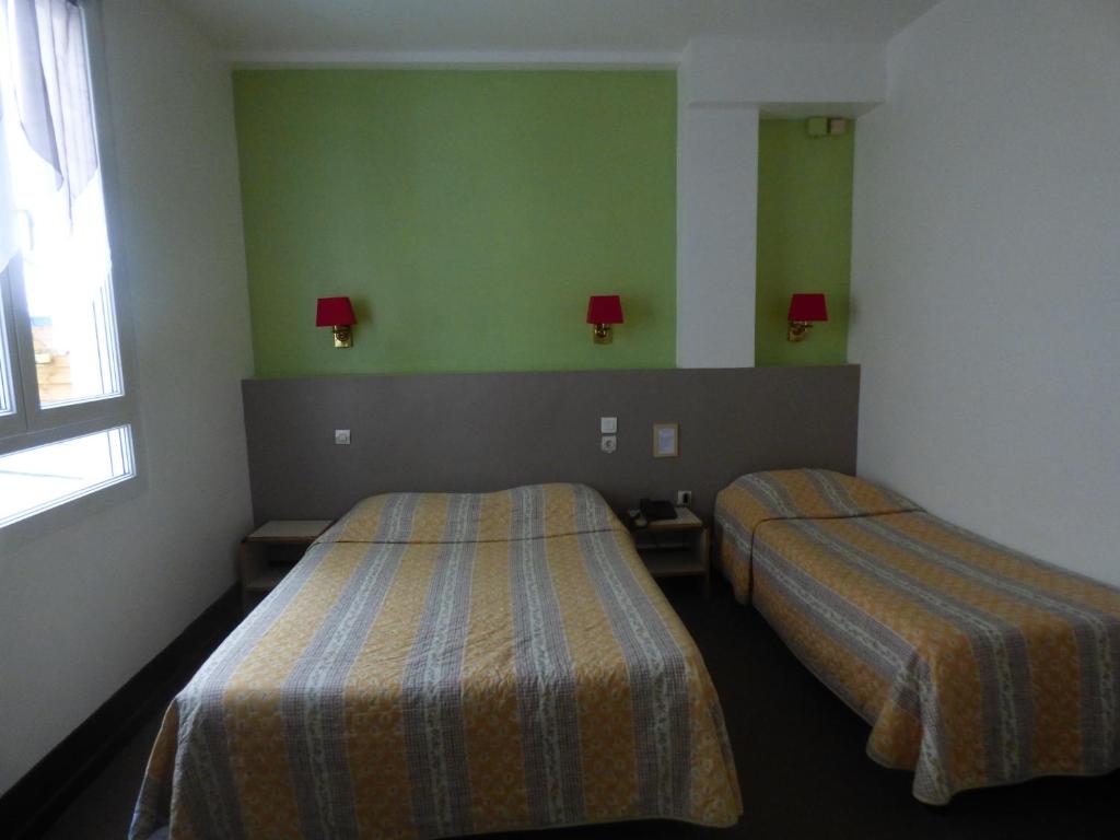 Un pat sau paturi într-o cameră la Hôtel Lamartine