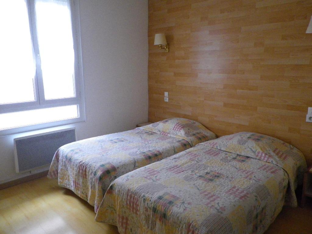 Postel nebo postele na pokoji v ubytování Hôtel Lamartine -Parking Dauphine