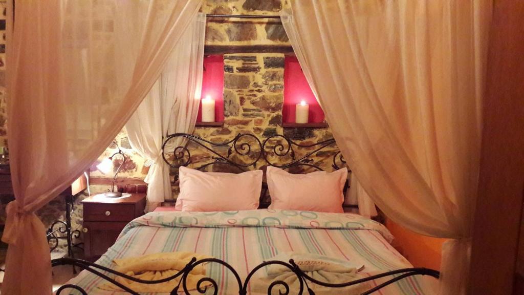 a bedroom with a large bed with a stone wall at Ippoliti in Palaioi Poroi