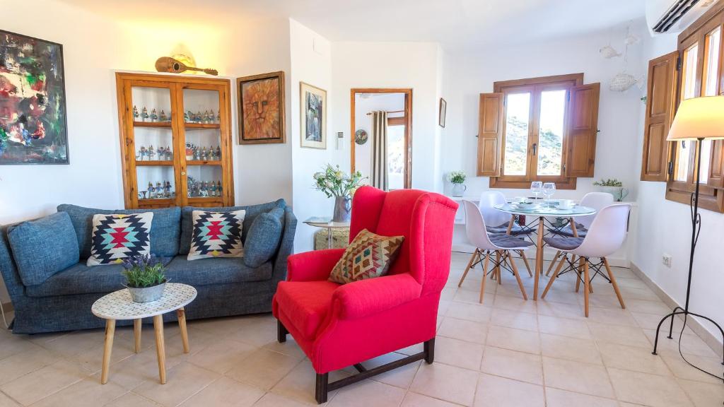 salon z czerwonym krzesłem i stołem w obiekcie Casa Baja Mojacar Pueblo w mieście Mojácar