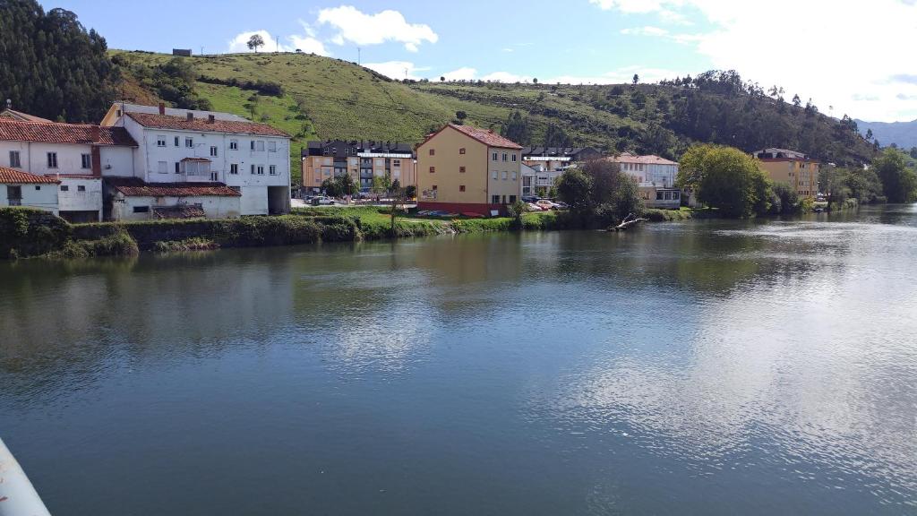 a river in a town with houses and buildings at Apartamento Unquera - Cantabria in Unquera