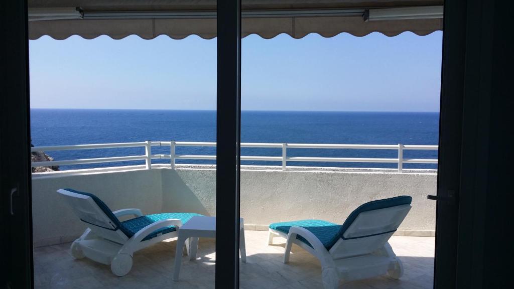two chairs and a table on a balcony with the ocean at Apartamento Panorama 180º in Altea