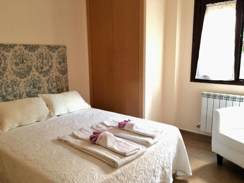 1 dormitorio con 2 toallas en una cama con ventana en Apartamentos Rurales Flor De Lavanda, en Brihuega