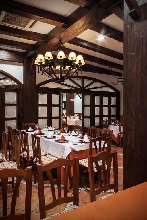 jadalnia ze stołem, krzesłami i żyrandolem w obiekcie Albenzaire Hotel Asador w mieście Fuensanta