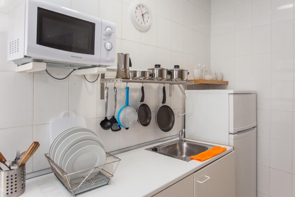 a kitchen with a sink and a microwave at Multi Apartamentos La Kasbah in Jerez de la Frontera