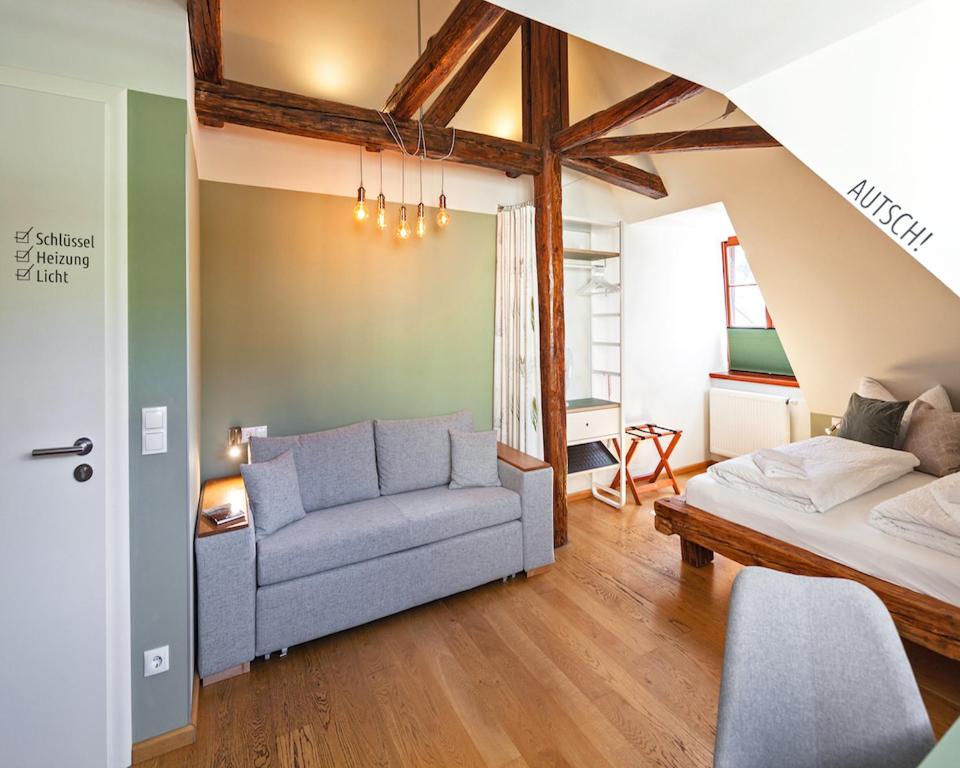 a living room with a couch and a bed at Bed and Breakfast am Schillerplatz in Dresden