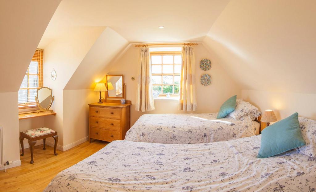 
A bed or beds in a room at Flowers of May Cottage
