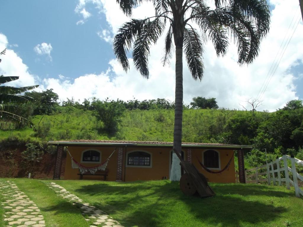 un palmier devant une maison dans l'établissement Cantinho na Roça, à Santo Antônio do Pinhal