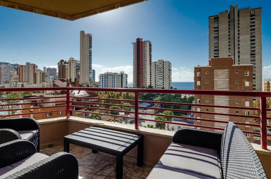 einen Balkon mit Stühlen und Stadtblick in der Unterkunft CarlosV in Benidorm
